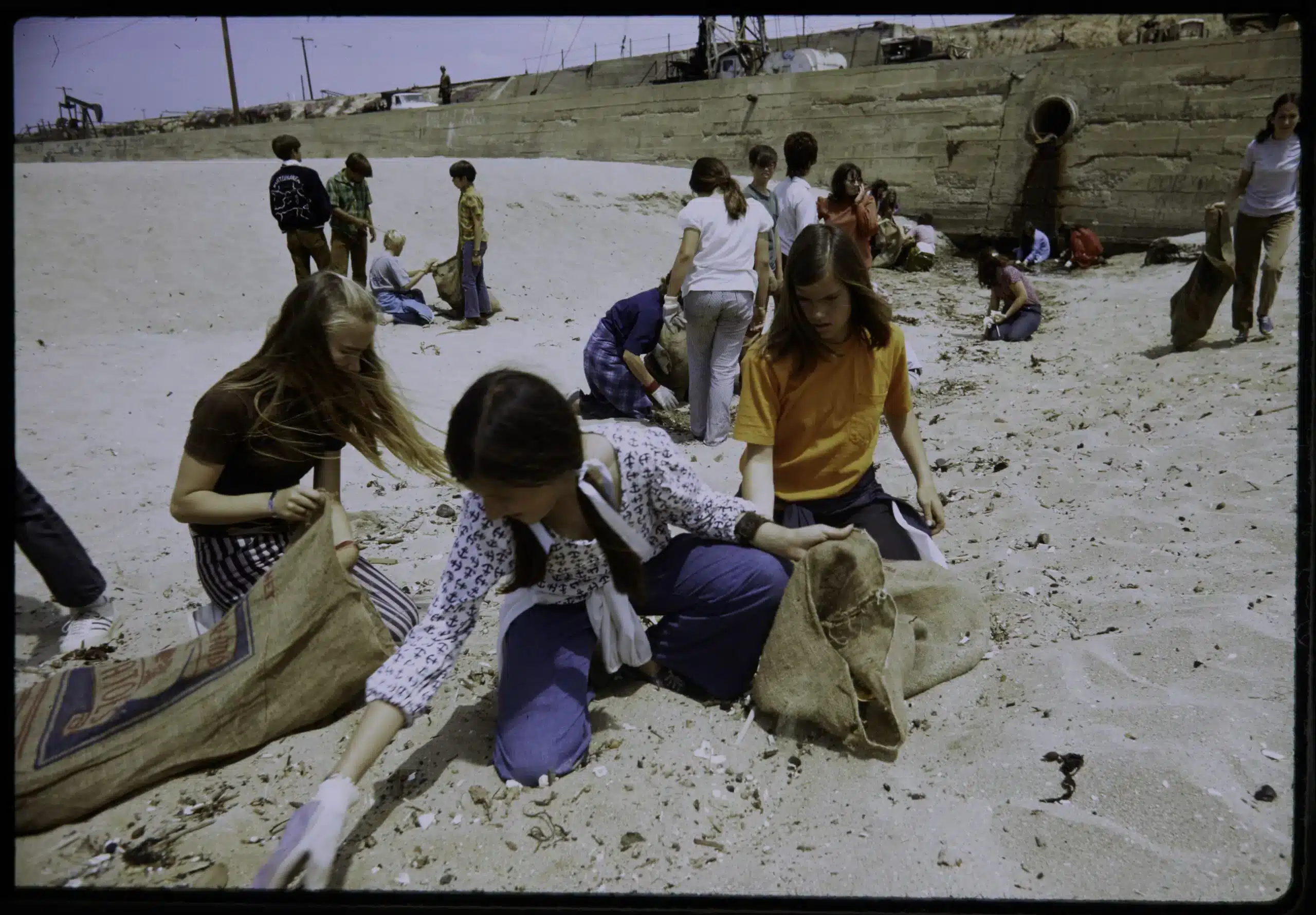 Eighth grade students spend recess picking up trash on Huntington Beach near oil wells, California, 1973. Gene Daniels for EPA’s Documerica Project.